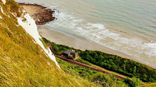 Rugged coast and railway line, Folkestone, Kent, England, UK, with chalk cliffs, sea views and tracks curving along the shoreline