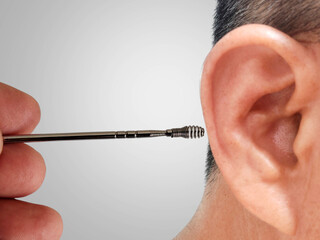 A man is putting ears pick metal, cleaning his right ear for healthcare on a white background.