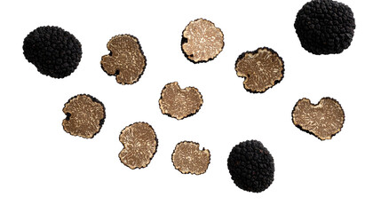 Several black and light brown truffle slices and whole truffles against a black background