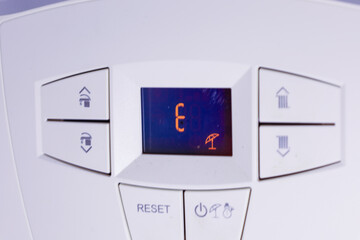 ​A top-down view of a white enamel gas stove with two black burners of different sizes and a...