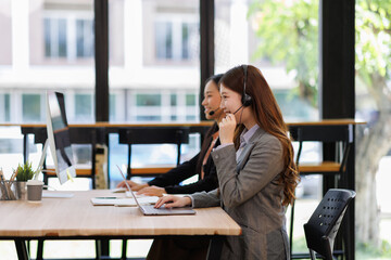 Diverse group of people work at call center or helpful customer service. Attractive women uses pc computer and monitor at busy agency office closeup. Phone talk and answer questions on modern hotline
