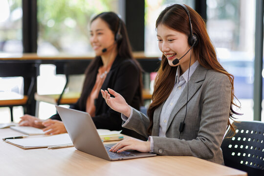 Diverse group of people work at call center or helpful customer service. Attractive women uses pc computer and monitor at busy agency office closeup. Phone talk and answer questions on modern hotline
