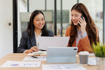 Obraz premium Group of confident business people point to graphs and charts to analyze market data, balance sheet, account, net profit to plan new sales strategies to increase production capacity. 