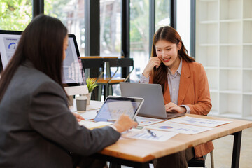 Group of confident business people point to graphs and charts to analyze market data, balance sheet, account, net profit to plan new sales strategies to increase production capacity.	
