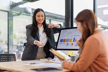 Group of confident business people point to graphs and charts to analyze market data, balance sheet, account, net profit to plan new sales strategies to increase production capacity.	
