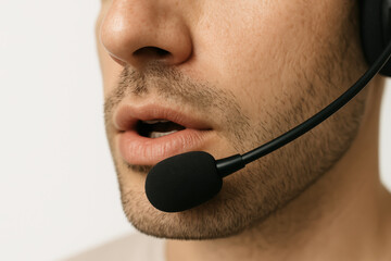 Closeup of man speaking with headset microphone, professional male customer service representative in communication support