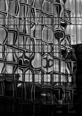 Black and white abstract reflection of architecture on a modern glass façade, creating warped...