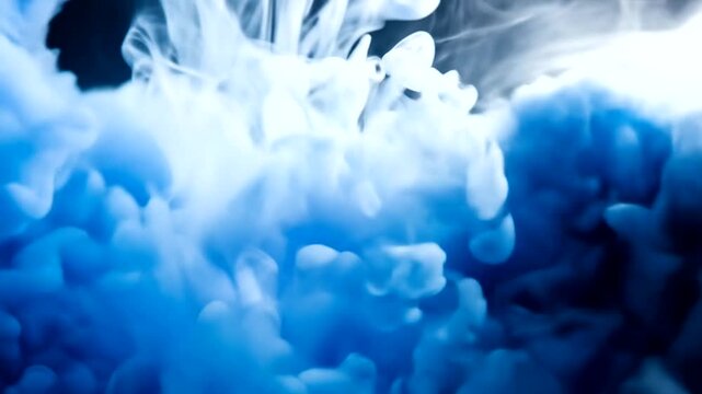 Vibrant, swirling hues of blue ink diffuse in a captivating display against a dark background.