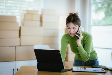 Obraz premium A young female entrepreneur managing online orders, packing parcels, and running a small e-commerce business with professionalism and happiness.