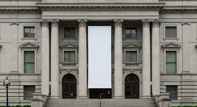 Grand neoclassical building facade with large blank banner hanging in the center for commercial usage and mockups