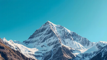 Majestic snow covered mountain peak under a clear blue sky