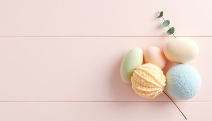 Pastel colored bath bombs and a sprig of green leaves on a light pink wood grain background, creating a calming, spa-like aesthetic