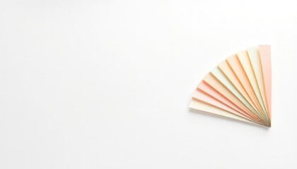 A minimalist flat lay of pastel colored paper fan on a white surface providing ample copy space