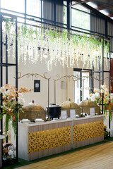 	A beautifully decorated food station featuring ornate gold chafing dishes and floral arrangements....