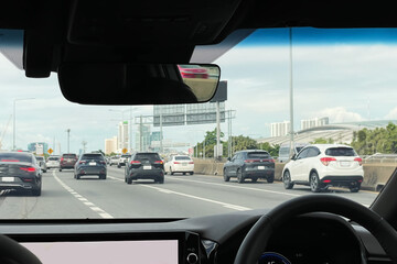 Photo image from inside the car show heavy traffic on motorway in Bangkok, Thailand on beautiful summer season. Image use for travel and transportation business background.