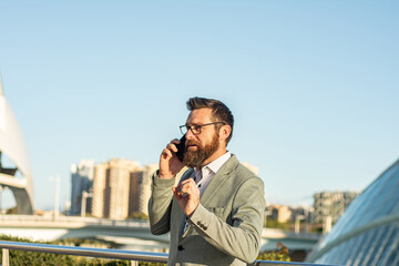 Mobile lifestyle. New technology. Handsome man with cell phone outdoors. Business communication. Phone for professional use. 3G. 4G. 5G. Businessman with phone in an urban setting.