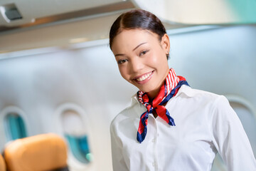 Smile face of airhostess in white uniform in service mind on airplane for service all passengers to travel by airline business.