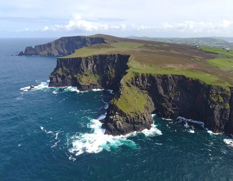Aerial view of rugged cliffs and a green coastline - Powered by Adobe