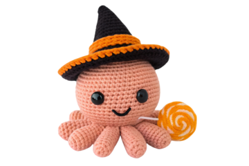 Pink crocheted octopus wearing black witch hat with orange band, holding orange lollipop, cute Halloween character, isolated on a transparent background