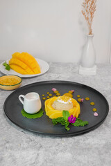 Mango Sticky Rice Delight: A beautifully plated dessert of mango sticky rice with a small dish of creamy coconut milk, offering a taste of tropical indulgence. 