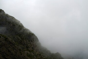 Lush green valley with foggy peaks and misty clouds