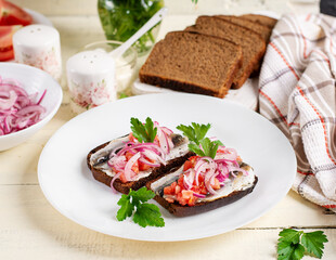 Sandwiches with anchovies, onions, and tomatoes. Diet food. Delicious food