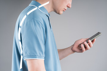 Incorrect posture due to gadget use, man with severe spinal curvature on gray background,...