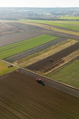 Tractor leaving dust trail while plowing field