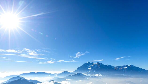 A bright sun shines in a clear blue sky above a range of distant, snow-capped mountains. The air is crisp and hazy - Powered by Adobe