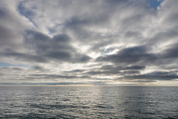 Obraz premium The sky is cloudy and the ocean is calm
