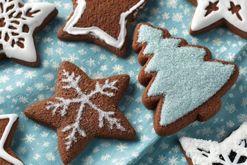 A festive plate of gingerbread cookies decorated with colorful frosting in the shapes of stars and Christmas trees.