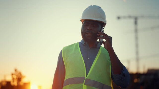 Modern boss of construction site taking by phone emotionally, decide of problems . Professional foreman working at construction site, modern technology and innovation in building, city development
