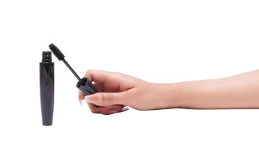 Hand holding mascara wand with open tube. Essential beauty cosmetic.