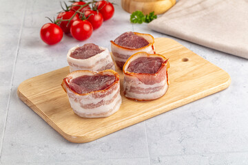 Raw pork tenferloin with bacon