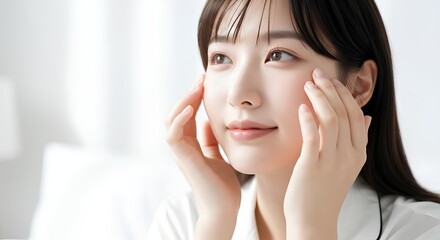 顔をマッサージする若い女性　美肌と保湿の美容イメージ