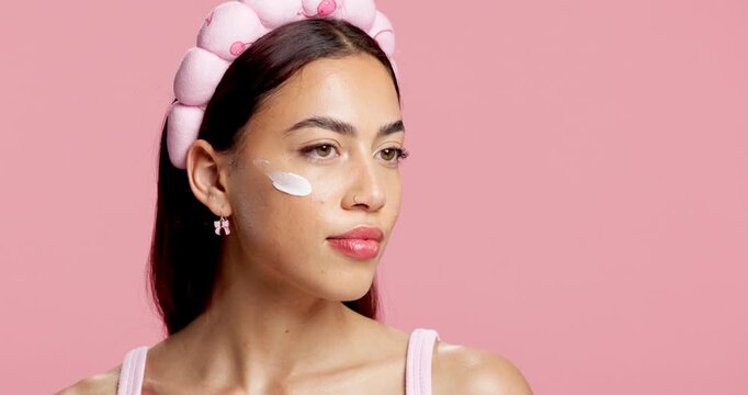 Apply, skincare and woman in studio with cream, natural cosmetic and wellness for healthy skin. Thinking, confident and female person with moisturizer, beauty and mockup space on pink background.
