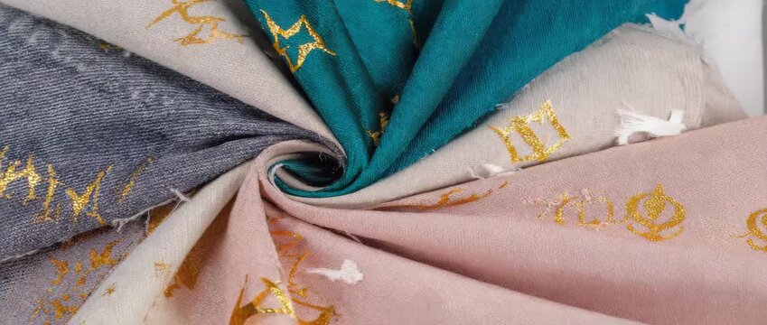 Pastel fabrics with gold accents twisted into a soft rosette on neutral ground. Fashion and textile store banner for craft and decor