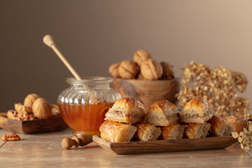 Baklava with walnuts and honey on a beige background.