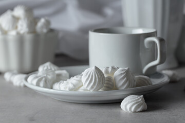 Vanilla meringue and coffee cup on a white marble table.