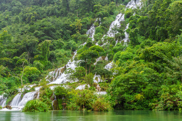 Obraz premium Waterfalls and streams among green mountains and clear waters in Guizhou Xiaoqikong Scenic Area