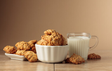 Oatmeal cookies and milk sit on a kitchen table.
