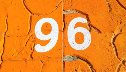 Close-up of the number 96 painted on an orange textured surface