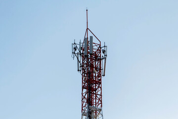 Telecommunication tower with antennas under blue sky