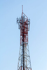Telecommunication tower with antennas under blue sky