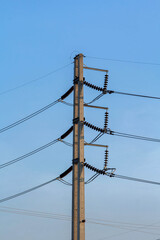High voltage electric power lines and pylons against a blue sky