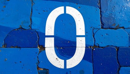 Close-up shot of a white number zero painted on a blue textured surface