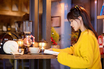 Oriental beauty drinking coffee in a coffee shop on a winter night