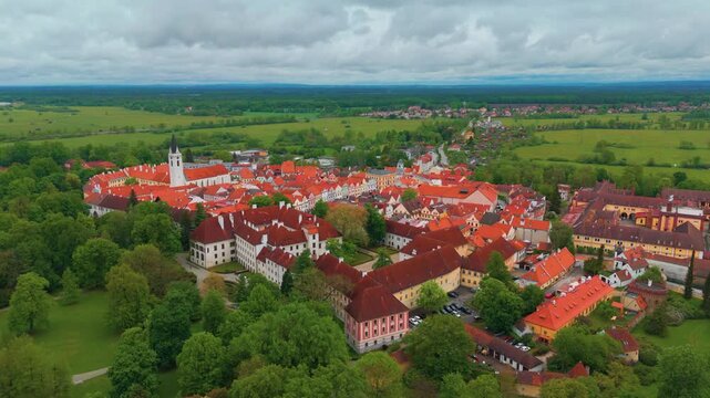 Majestic aerial top down view footage capturing the historic town of Třeboň Wittingau in South Bohemia, Czech Republic, featuring the iconic Třeboň Castle, charming red-roofed buildings, and surroundi