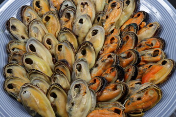 Steamed fresh peeled mussel serving on the plate. Famous seafood on ice menu in restaurant. 