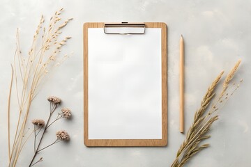 Blank clipboard with dried flowers and pencil on textured background